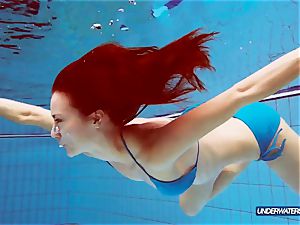 red-haired in blue bathing suit demonstrating her bod
